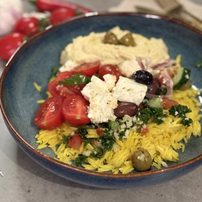 Smakrik tallrik med ris, hummus och fräsch medelhavssallad