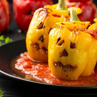 Smakrika ugnsgrillade fyllda halloween paprikor i tomatssås
